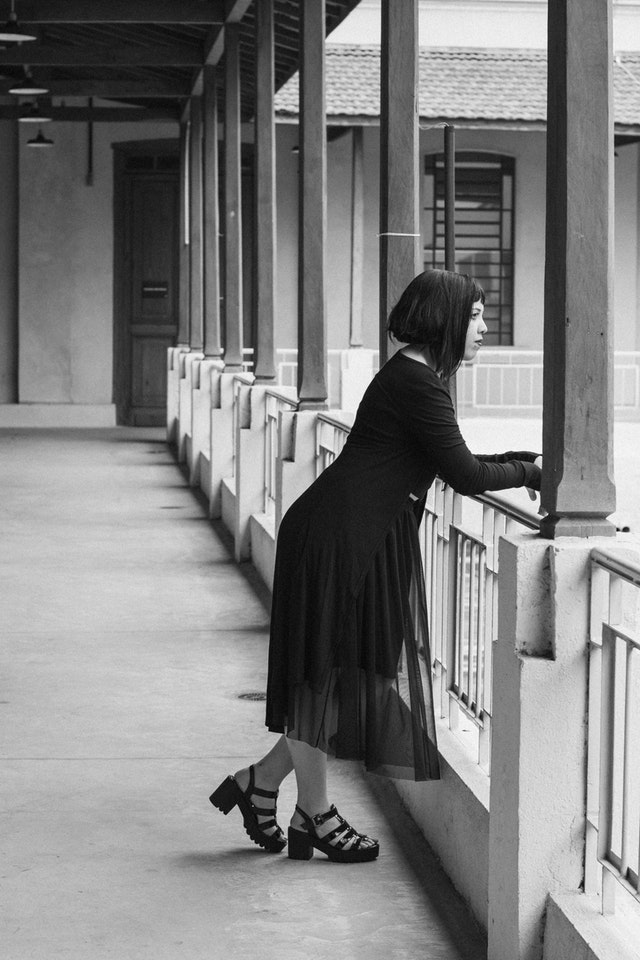 Vrouw leunt over balustrade en vraagt zich jaloers af of haar ex een ander heeft