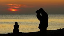 Alleen aan de kust met haar rug naar haar ex en zijn nieuwe vriendin – een pijnlijk moment van jaloezie.