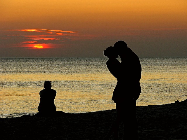 Alleen aan de kust met haar rug naar haar ex en zijn nieuwe vriendin – een pijnlijk moment van jaloezie.