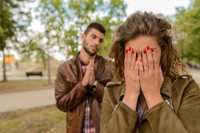 Vrouw wendt zich af terwijl haar ex wanhopig achter haar staat – laat zien waarom rust uitstralen sterker is dan smeken in een ex terug methode.