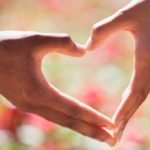 Man en vrouw maken samen een hartje met hun handen – symbool voor een herstelde relatie dankzij de juiste ex terug methode.