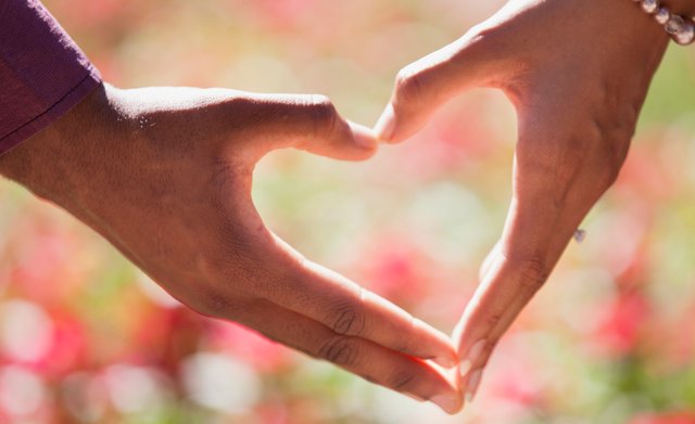 Man en vrouw maken samen een hartje met hun handen – symbool voor een herstelde relatie dankzij de juiste ex terug methode.