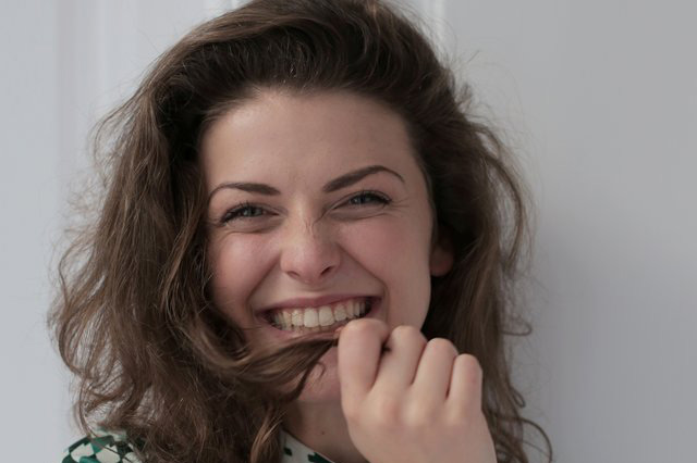 Vrouw lacht verlegen na een onverwacht compliment van haar ex.