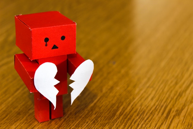 Een poppetje met gebroken hart, symbool voor spijt na een relatiebreuk.