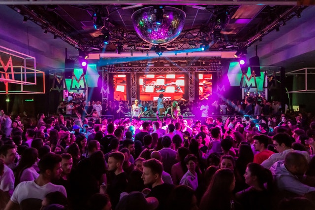 Publiek geniet van een concert, symbool voor een ex die het leven viert na de relatiebreuk.
