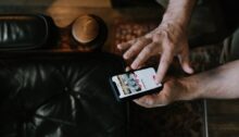 Hand die telefoon vasthoudt met dating-app Tinder, klaar om naar rechts te swipen voor ex.