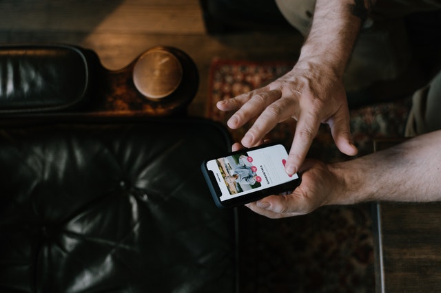 Hand die telefoon vasthoudt met dating-app Tinder, klaar om naar rechts te swipen voor ex.