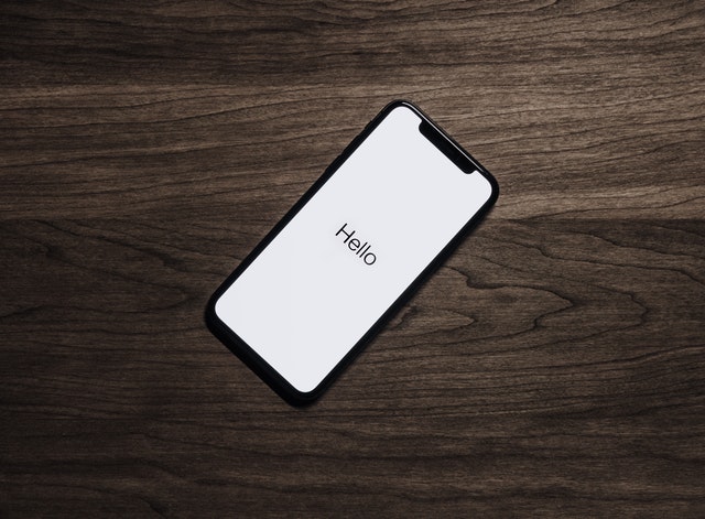 Een telefoon op tafel met de tekst "Hello", symbool voor weer contact met je ex krijgen.