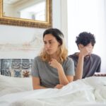 Man en vrouw zitten in bed. Er is zichtbare afstand omdat een van hen is vreemdgegaan