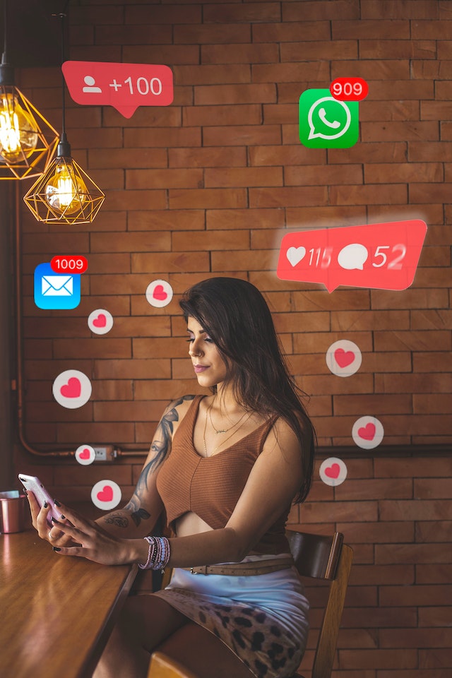 Vrouw met een telefoon in haar hand en opvallend veel social media activiteit. Een duidelijk signaal van niet over een ex heen zijn.