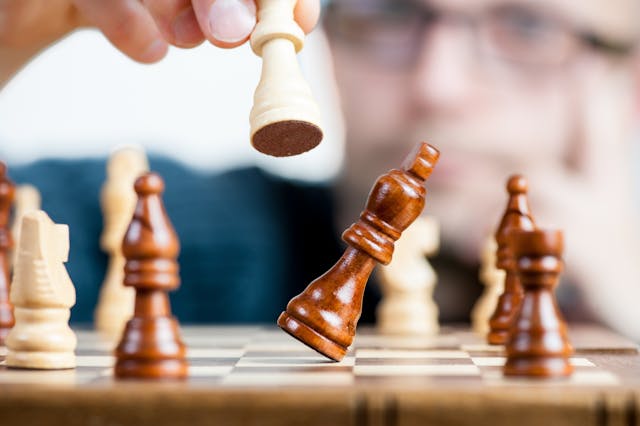 Een schaakspel waarbij de koning wordt geslagen, symbool voor manipulatie en controle in een relatie.