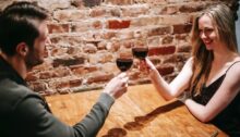 Man en vrouw die samen in een restaurant zitten en proosten, symbool voor een date met je ex.