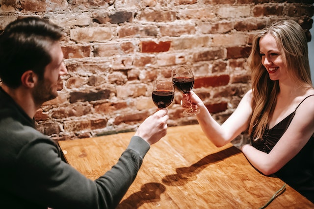 Man en vrouw die samen in een restaurant zitten en proosten, symbool voor een date met je ex.