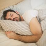 Man ligt in bed te slapen en droomt over zijn ex.