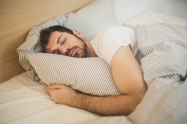 Man ligt in bed te slapen en droomt over zijn ex.