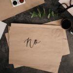 Papier met NO geschreven op een bureau met allerlei spullen, nee zeggen tegen je ex.