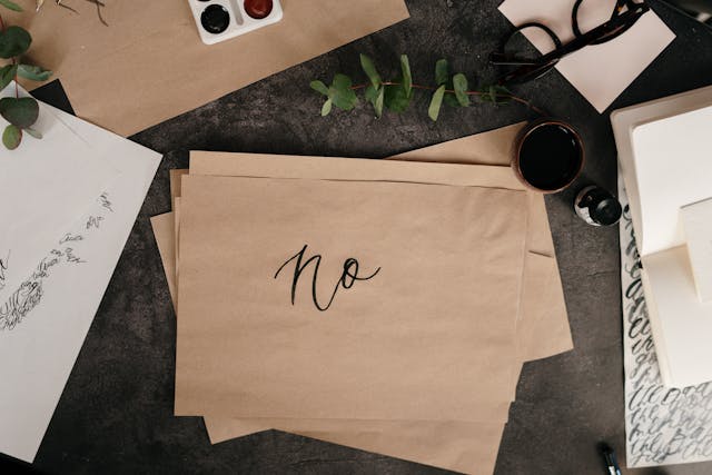 Papier met NO geschreven op een bureau met allerlei spullen, nee zeggen tegen je ex.