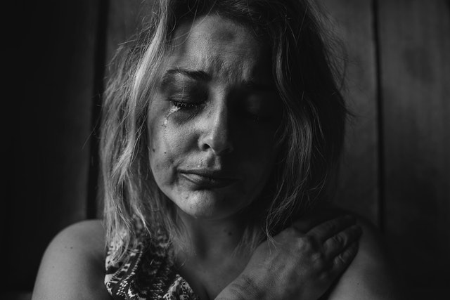 Vrouw met betraand gezicht, symbolisch voor huilend je ex smeken om je terug te nemen.