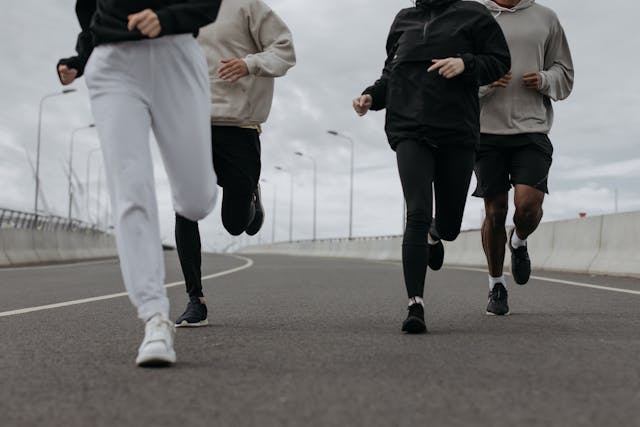 Een groep mensen die samen buiten aan het joggen is, symbool voor zelfzorg en persoonlijke groei na een relatiebreuk.