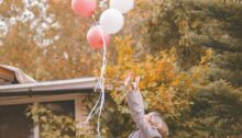 Vrouw die balonnen loslaat als symbool voor het loslaten van je ex.