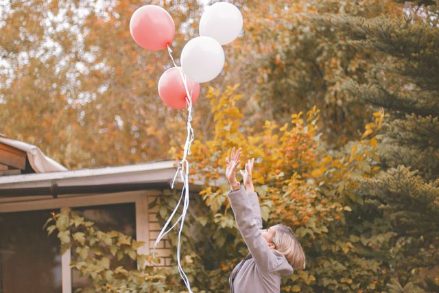Vrouw die balonnen loslaat als symbool voor het loslaten van je ex.