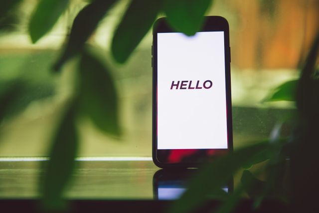 Smartphone met de tekst Hello op het scherm als symbool voor het contact luchtig opbouwen.