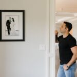 Man kijkt naar zijn trouwfoto aan de muur, hij mist zijn ex-vrouw na de scheiding.