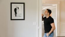 Man kijkt naar zijn trouwfoto aan de muur, hij mist zijn ex-vrouw na de scheiding.