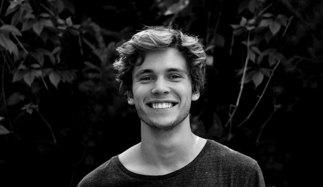 Man lacht zelfverzekerd, symbool voor positief en volwassen blijven als je ex negatief over je praat.