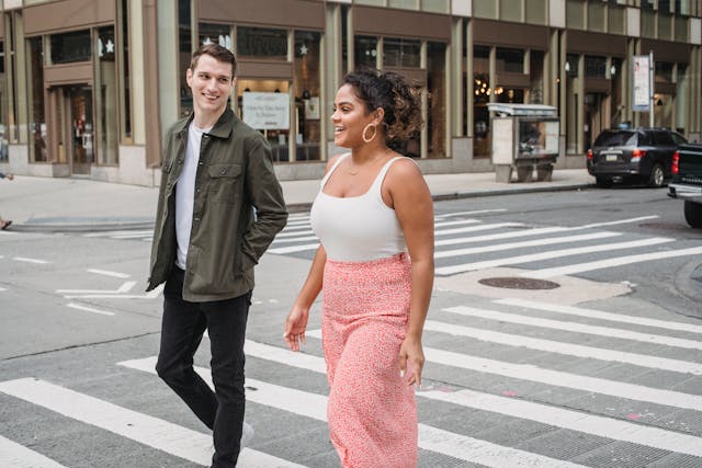 Man en vrouw lopen lachend samen over een zebrapad, een teken dat het vertrouwen langzaam aan het herstellen is.