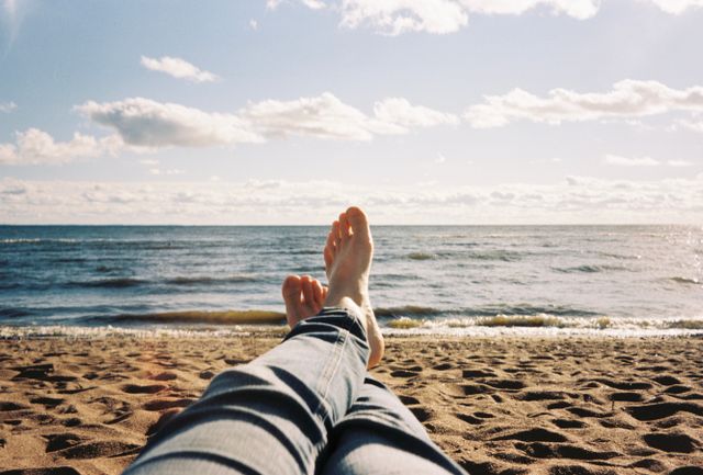 Iemand zat op het strand, deed niks richting ex, maar maakte wel een foto van het strand en de zee met de eigen voeten in beeld.